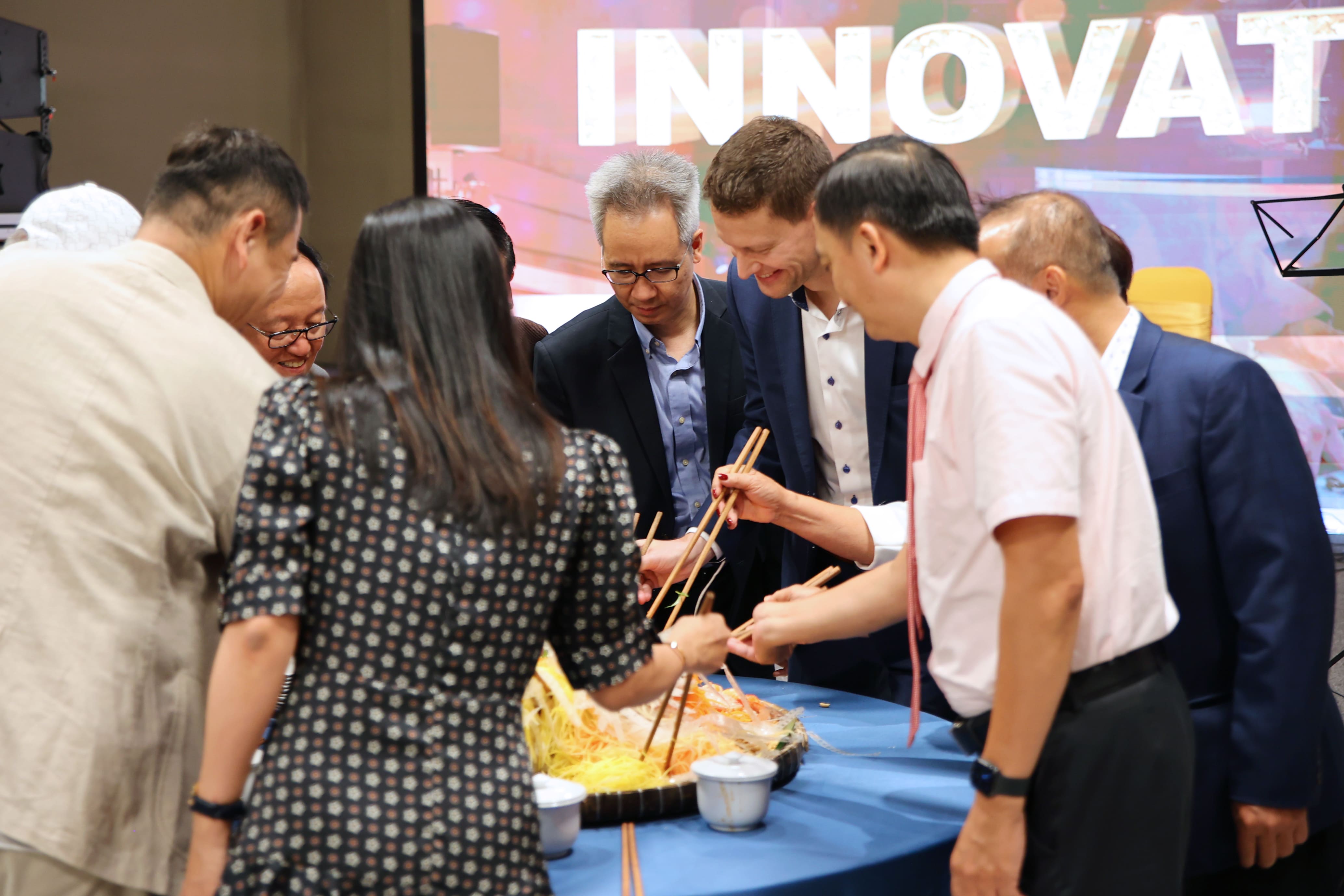 the_memorable_moment_of_the_honored_guest_participating_in_making_the_mixed_rice_paper_dish